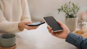 La imagen representa de forma minimalista y realista esta transformación digital. En la escena, dos personas realizan un intercambio económico mediante teléfonos móviles en un ambiente cálido y contemporáneo. La ausencia de elementos visuales excesivos transmite simplicidad y modernidad, reforzando la idea de pagos rápidos, cotidianos y discretos asociados al crecimiento de las finanzas digitales en España.